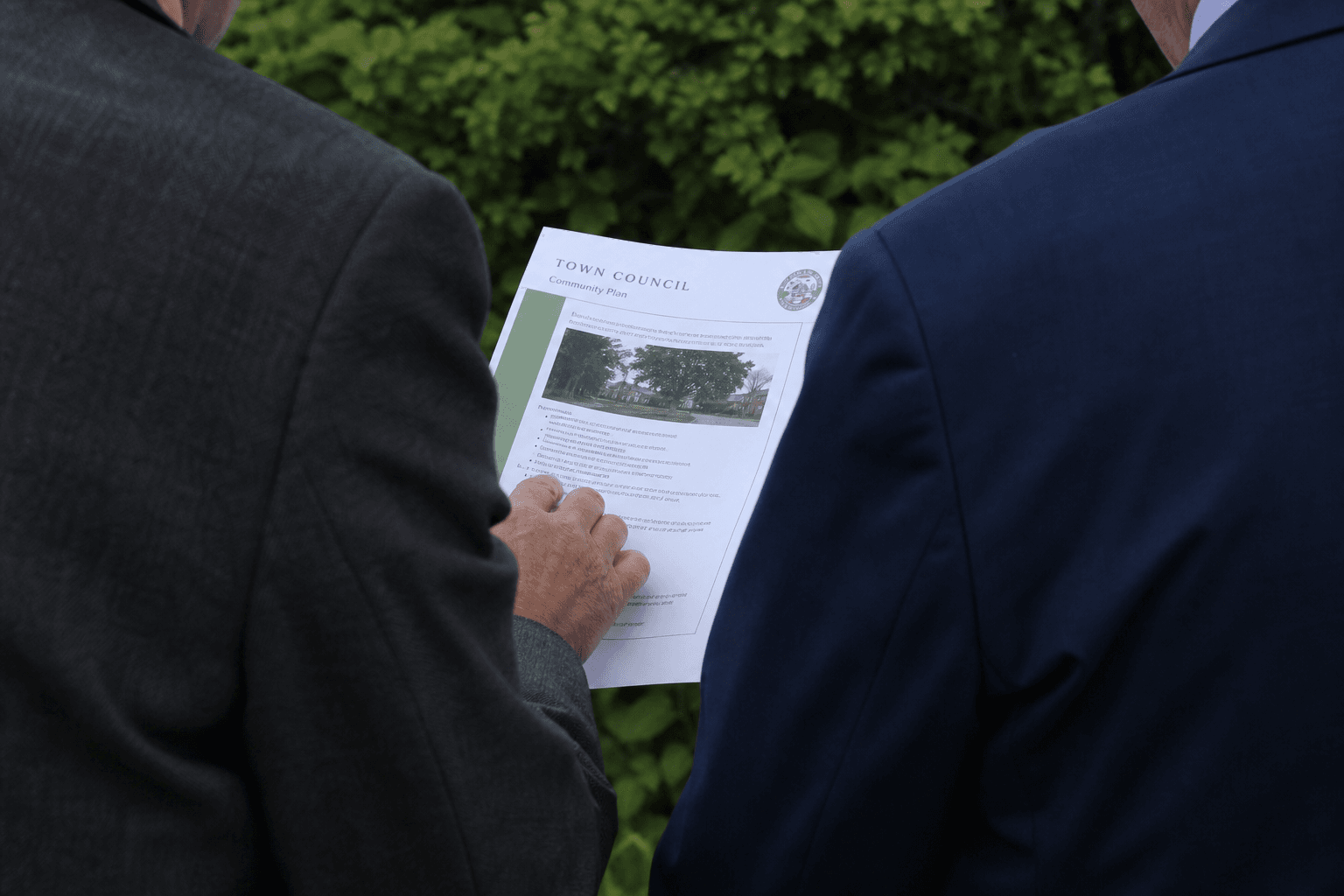 Code Of Conduct Document Two councillors reviewing a council document outdoors