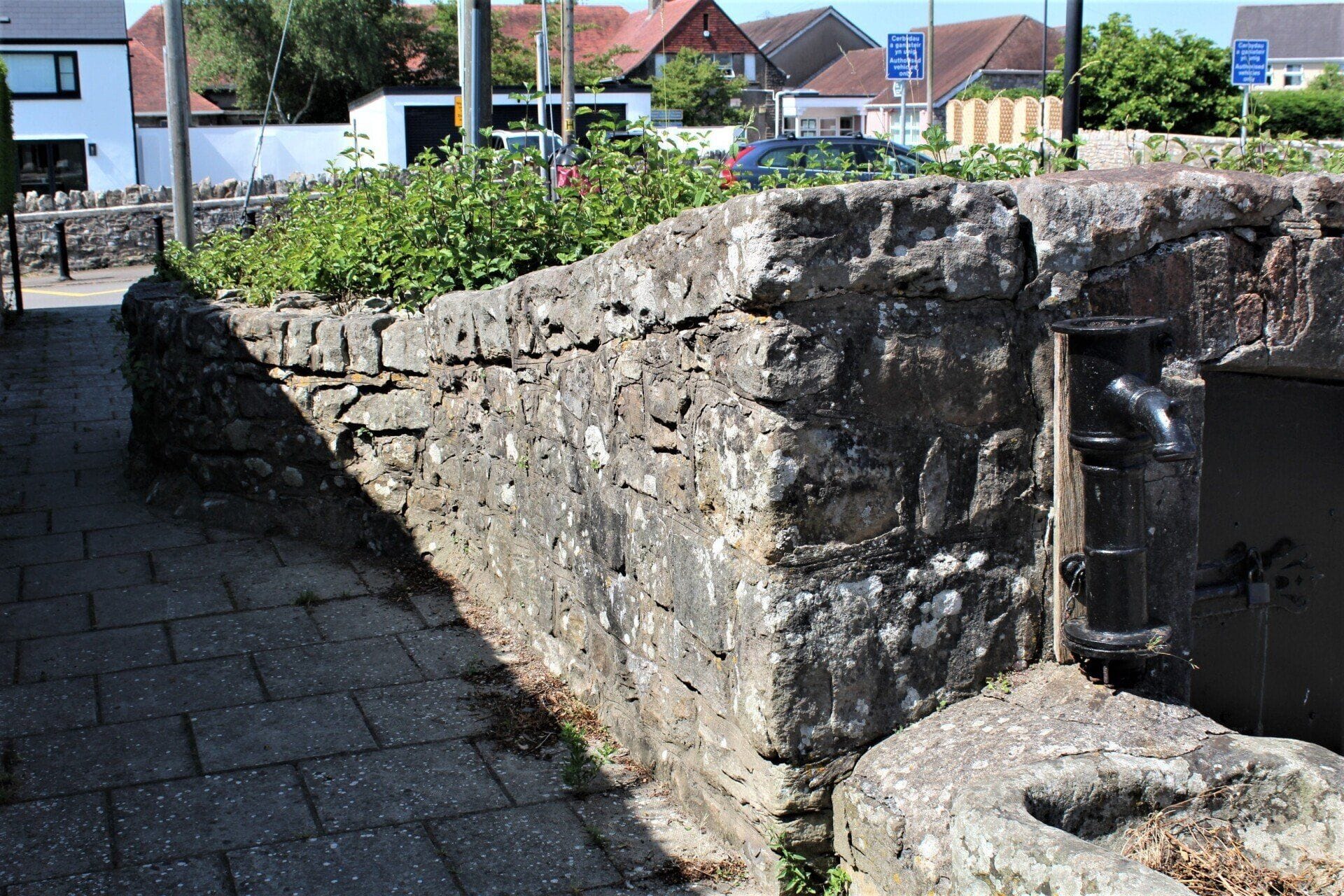 Laleston ancient village well — stone walls and metal pump, top of Well Street